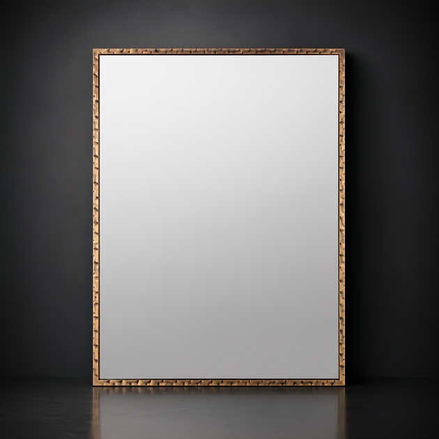 Rectangular Surya Alchemist wall mirror with a hammered gold iron frame and beveled glass, leaning against a dark wall.