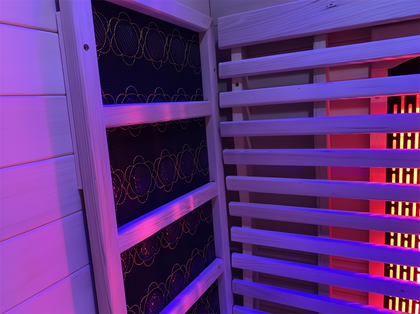 Lumin Infrared Sauna Two interior with light wood panels, black heating elements, and red/purple lighting.