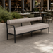 Surya Antibes outdoor sofa with brown and beige striped Sunbrella fabric, black aluminum base, and bolster back.