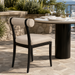Surya Antibes armless dining chair with black aluminum frame and beige Sunbrella upholstery on a patio.