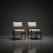 Two Surya Bergene dining chairs with light beige upholstery and brown rubber wood frames.