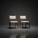 Two Surya Bergene dining chairs with light beige upholstery and brown rubber wood frames.