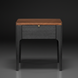 Brown oak veneer top end table with a black manufactured wood drawer and rubber wood legs.