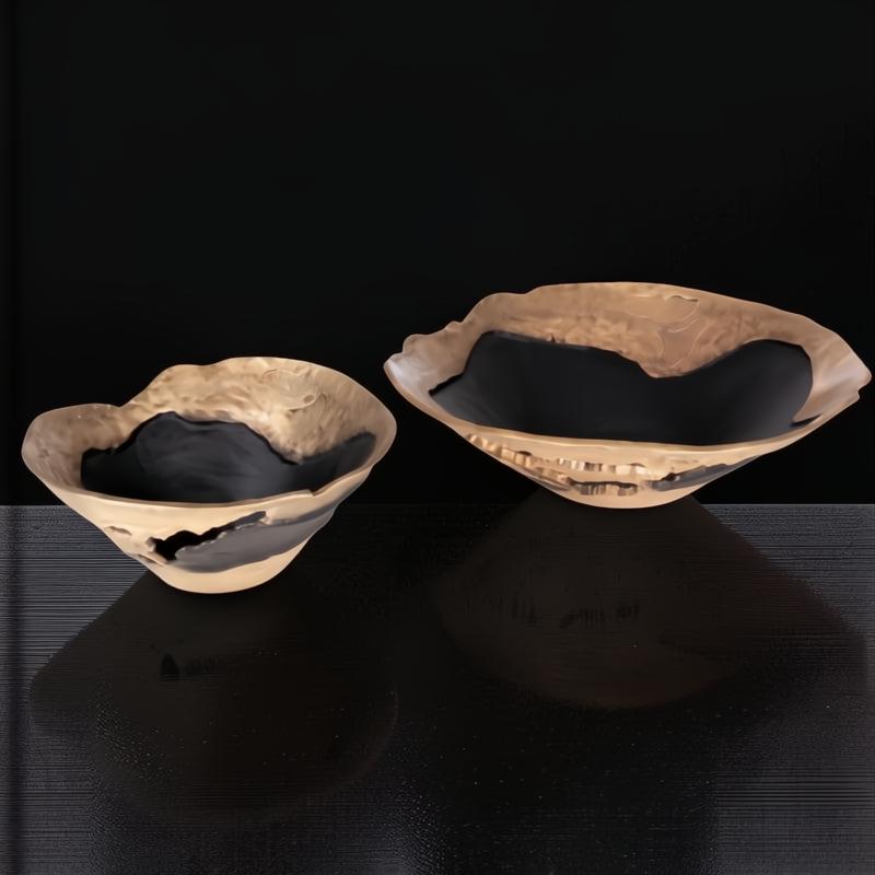 Two modern sculptural aluminum decorative bowls, AOA-001, with a sleek metallic finish and black interiors.