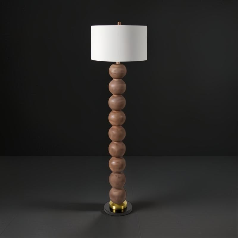 Surya Algarve 62" brown and gold floor lamp with a stacked resin body, black iron base, and white linen shade.