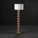 Surya Algarve 62" brown and gold floor lamp with a stacked resin body, black iron base, and white linen shade.