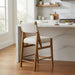 Surya Bergene light beige upholstered counter stool with brown rubber wood frame and angular backrest.