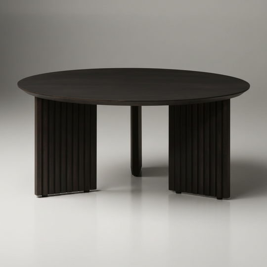 Blackened mango wood Surya Agnes coffee table with a round top and zigzag fluted legs.