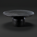 Black sandblasted mango wood Koben coffee table with a round top and turned base, showcasing exposed wood grain.