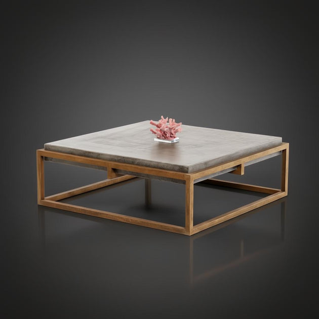 Industrial-modern concrete coffee table with a sleek metal frame, featuring a pink coral decor.
