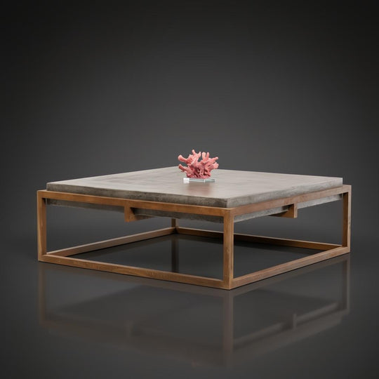 Industrial-modern concrete coffee table with a sleek metal frame, featuring a coral centerpiece.