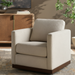 Beige polyester swivel chair with squared arms and a brown base, in a living room setting.