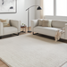 Light gray linen Surya Dylan sofa and armchair with black metal bases in a modern living room.