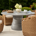 Surya Marvella indoor/outdoor dining chair with dark brown wicker, cream cushion, and graceful profile.