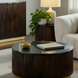 Round Surya Nems coffee table with black polished marble top, dark brown mango wood base, and gold brass accents.