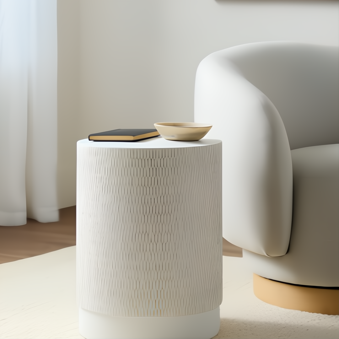 Surya Amenet round end table with white textured base, gold matte top, next to a cream chair.