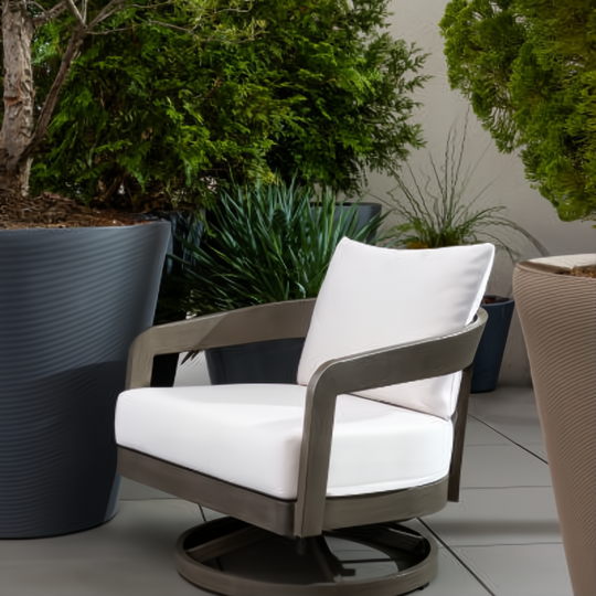 Gray Surya Daniella outdoor swivel chair with white Sunbrella cushions and a hand-painted aluminum base.