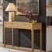 Slim brown oak veneer console table with two drawers and a brown/metallic brass base.