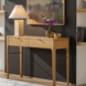 Slim brown oak veneer console table with two drawers and a brown/metallic brass base.