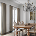 Hand-knotted wool area rug with traditional design in charcoal, wheat, and taupe under a wooden dining table.
