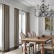 Hand-knotted wool area rug with traditional design in charcoal, wheat, and taupe under a wooden dining table.