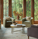 Surya Engel coffee table with white marble top and metallic brass iron base in a living room.