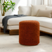 Surya Mohave MHPF-004, a round, rust-colored, textured polyester pouf on a light rug.