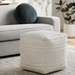 Knitted Surya Matthew pouf in off-white with geometric patterns, serving as a footrest or accent piece.