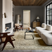 Elegant living room with a Surya Capelli Accent Table Lamp, a cream fabric sofa, and a patterned rug.