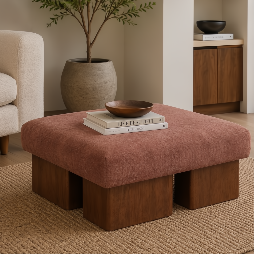 Surya Mirava Ottoman, a large square upholstered ottoman with a textured pink polyester cover and four dark wood block legs.