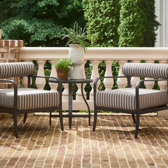 Two Surya Antibes accent chairs with black frames and striped cushions on a brick patio.