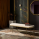Surya Engel bench with a long, streamlined beige polyester top and metallic brass iron base.
