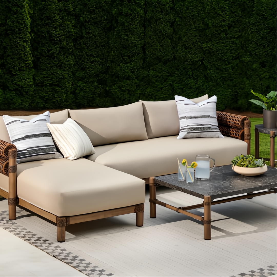 Brown Surya Porta sectional with beige Sunbrella cushions, rattan accents, and a dark stone coffee table.
