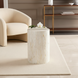 Round Surya Iridescent End Table with tan and ivory shell detailing, styled next to a cream accent chair.