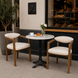 Two Surya Henderson dining chairs with light gray polyester upholstery and rubber wood frames, paired with a marble-top cafe table.