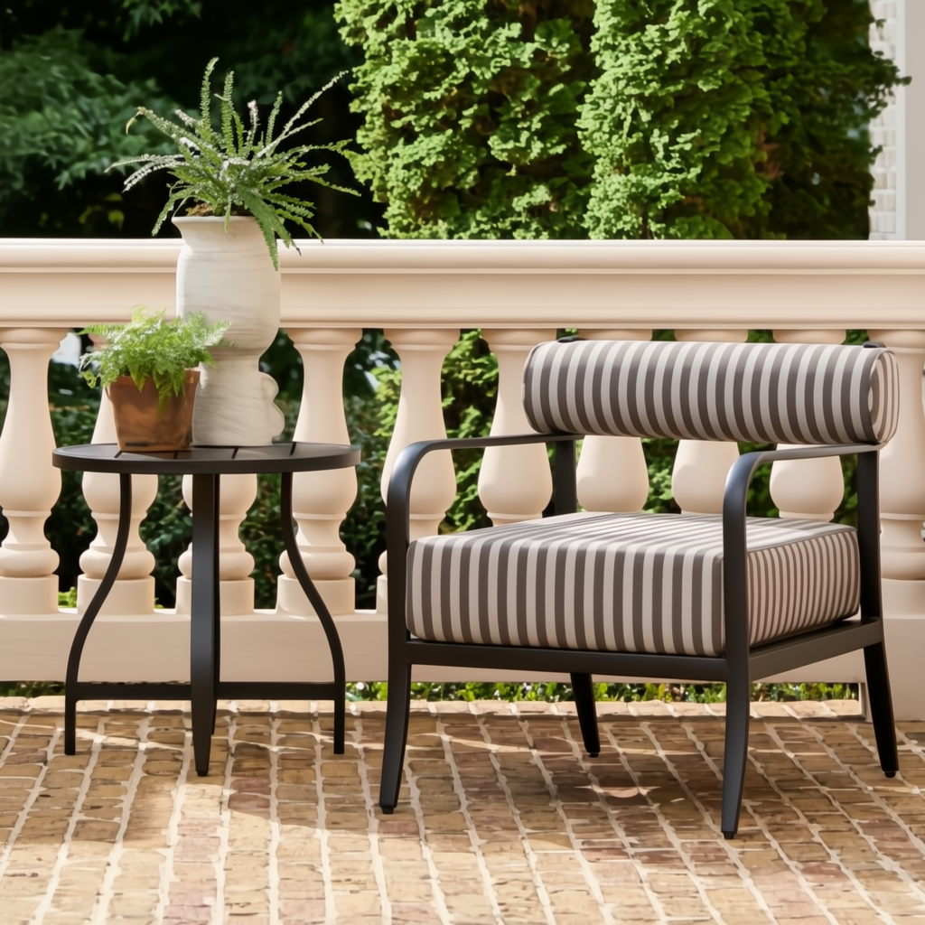 Black aluminum round outdoor end table with curved legs next to a striped patio chair.