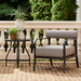 Black aluminum round outdoor end table with curved legs next to a striped patio chair.