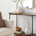 Modern white ceramic decorative accent set with sculptural vase-like forms on a console table.