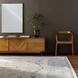 Surya Alchemist rectangular wall mirror with hammered gold iron frame above a wooden console.