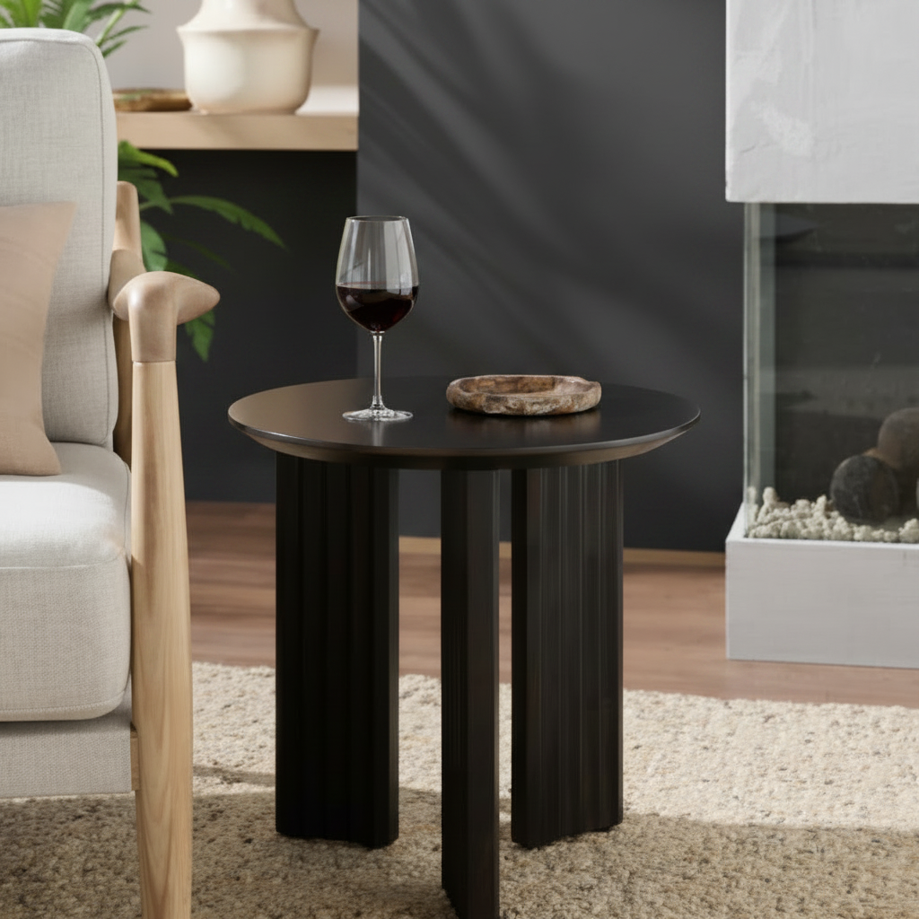 Blackened mango wood round end table with zigzag fluted legs and a beveled edge top.