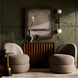 Surya Alva End Table with black marble top and metallic bronze iron base beside a beige chair.