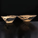 Two modern sculptural aluminum decorative accent bowls with a sleek metallic finish and black interiors.