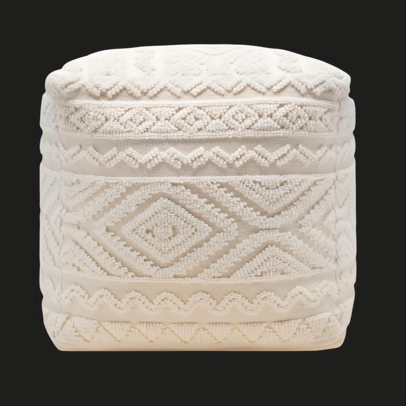 Surya Matthew Pouf, a cream knitted pouf with intricate beaded geometric patterns, on a dark background.