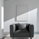 Surya Dylan Accent Chair, a minimalist modern charcoal leather chair with a black iron base and gray pillow.
