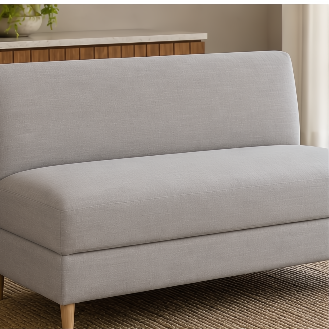Light gray upholstered banquette bench with natural ash wood legs on a woven rug.