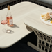 Cream Surya Winder End Table with handwoven PE rope detail, holding a glass of rosé and snacks.