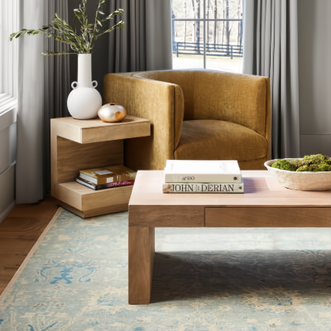 Brown lacquered mango wood Surya Coburn end table with open storage beside a gold chair.