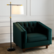 Modern black and gold floor lamp with an ivory linen shade next to a dark green velvet accent chair.