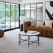 Surya Amenet End Table, a compact round black iron table with hammered detailing, in a modern living room.