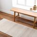 Surya Abby ABB-2301 hand-woven recycled PET yarn area rug with subtle beige stripes on a wood floor.